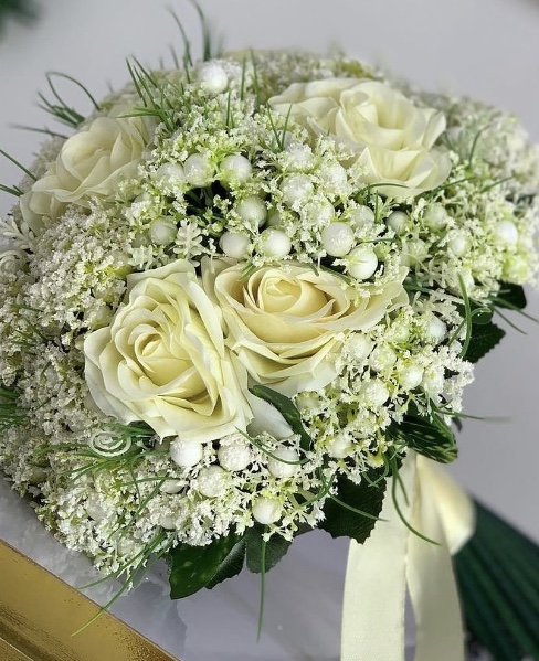 Wedding bouquet of ivory roses and delicate white flowers